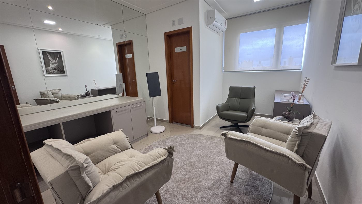 Sala de espera do consultório, com poltronas claras e iluminação suave